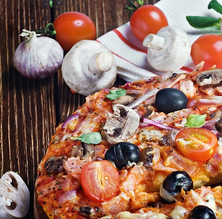 pizza with mushrooms and cheese on a wooden tableの写真素材