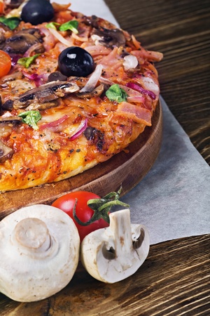 Delicious italian pizza served on wooden tableの写真素材