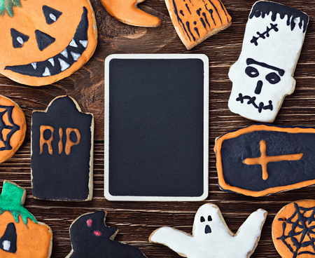 Handmade Halloween cookies on a wooden background and a blackboardの写真素材