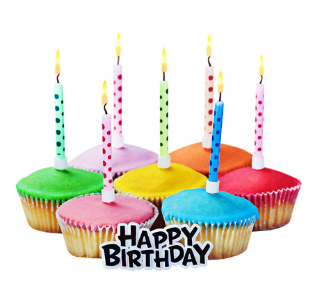 colorful happy birthday cupcakes with candles on white backgroundの写真素材