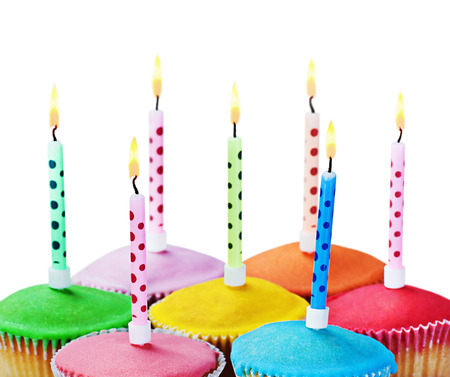 colorful happy birthday cupcakes with candles on white backgroundの写真素材