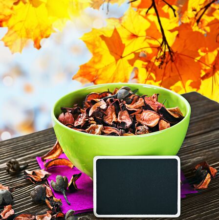 dried flowers and a blackboard for the text on a background of autumn leavesの写真素材
