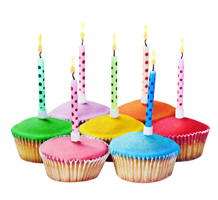colorful happy birthday cupcakes with candles on white backgroundの写真素材