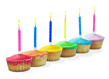 Birthday cupcakes in different colors isolated on white backgroundの写真素材