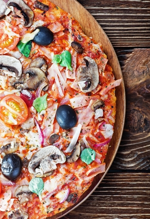 pizza with mushrooms and cheese on the tableの写真素材
