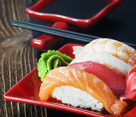 Japanese seafood sushi and chopsticks on a red plateの写真素材