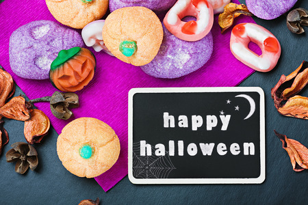 sweets and candies for Halloween and blackboard with congratulationsの写真素材