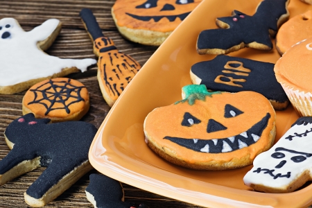 Halloween cookies on orange plate and wooden tableの写真素材