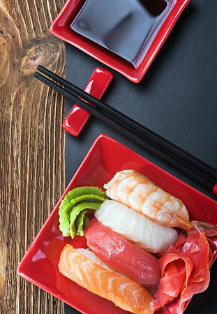 Japanese seafood sushi and chopsticks on a red plateの写真素材