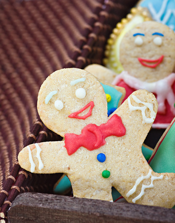 smiling gingerbread man cookies and the rest in a gift box on a white background. Focus on the first...