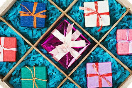 wooden box with gifts in colorful packaging. Focus on the central giftの写真素材