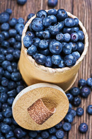 Blueberries in a basket is scattered on the wooden tableの写真素材