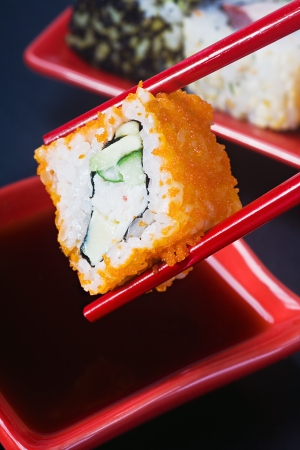 chopsticks hold roll and dip in sauceの写真素材