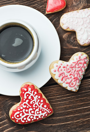 Heart shaped cookies baked on valentines day and a cup of coffee. Focus on biscuitsの写真素材