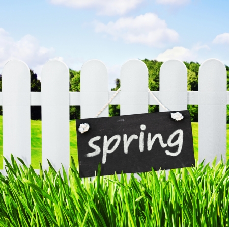blackboard with the word spring hanging on the fence lawnの写真素材