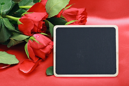 red roses and blackboard with a place for a congratulatory textの写真素材