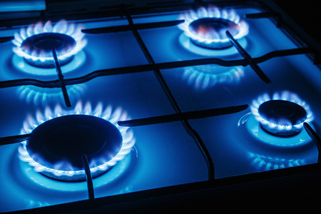 Blue flames of gas burning from a kitchen gas stove. Focus the front edge of the hotplateの写真素材