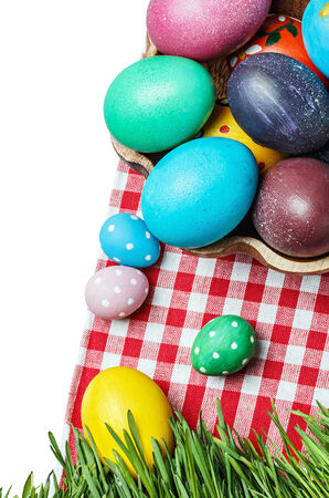Colorful easter eggs in a wooden bowl isolated on whiteの写真素材