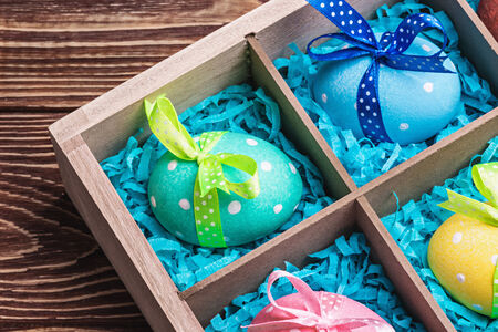 assorted colorful painted easter eggs in a wooden box
