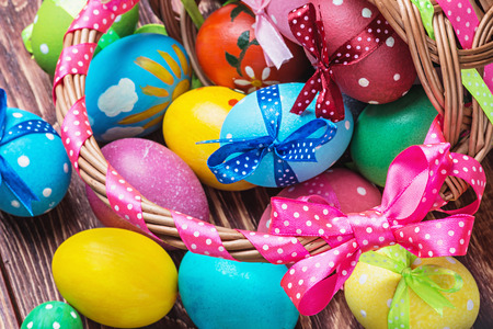 easter eggs in brown basket. Focus on the pink bow and handle basketの写真素材