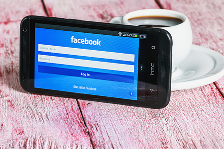 Moscow, Russia - March 18, 2014: Entrance to the social network facebook via mobile phone HTC. The biggest social network in the world. Was founded in 2004 by Mark Zuckerberg.のeditorial素材