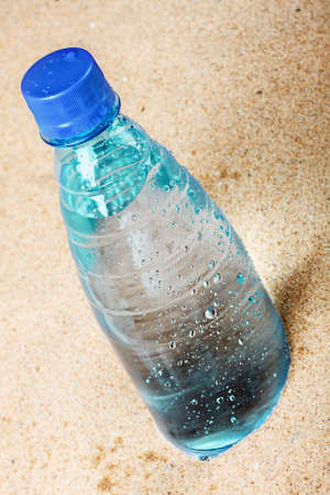 cold bottle of water on the hot sandの写真素材