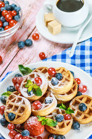 waffles with berries on the table. Focus on the red currants in the middle of the frameの写真素材