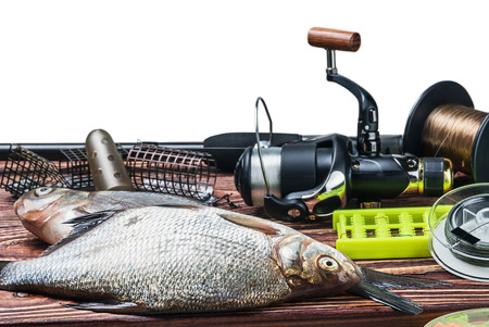 fishing tackle and caught fish on the table isolated on white background