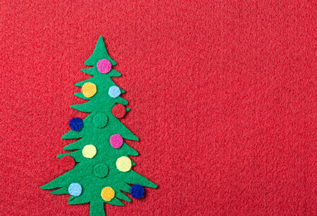 Christmas tree with toys made of felt on a red の写真素材