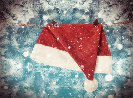 Christmas Hat Santa claus hanging on a rope with clothespins. toning image
