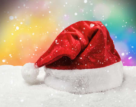 Santa hat on snow on a colored backgroundの写真素材