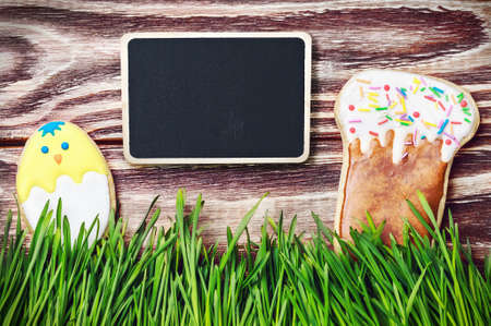 Easter homemade gingerbread cookie over wooden table and black board for congratulations