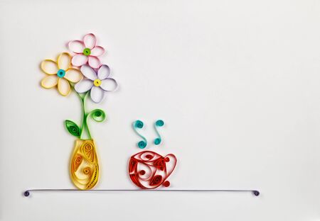 colorful flowers in a vase and a hot cup made of quilling. Location can be used for the textの写真素材
