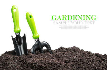 garden tools in soil isolated on white background. The text is an example and can be easily removedの写真素材