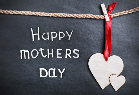 heart from a tree on a black background with the text greetings. happy mothers dayの写真素材