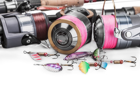 Fishing Tackle Spinning isolated on white background. Focus on a reel with a pink braided fishing line and lures convent...の写真素材