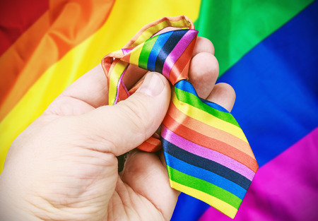 tie in the colors of the rainbow in her handの写真素材