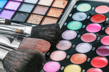 Make-up colorful eyeshadow palettes with makeup brushes. Focus in the middle of the frame on the black brush. Shallow depth of fieldの写真素材