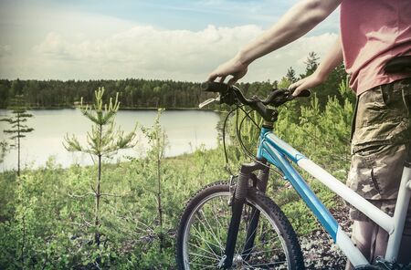 cyclist on the background of forest lake. Focus on the bikeの写真素材