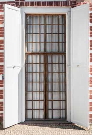 old wooden door with shutters in a brick building.の写真素材