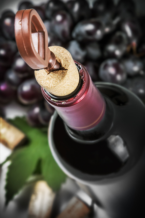 opening a bottle of wine and grapes on the table. Focus on corkscrewの写真素材