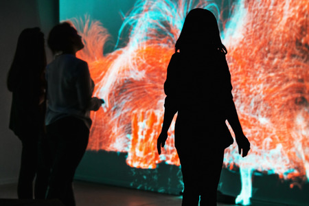 Moscow, Russia - January 28, 2016: people standing in front of an interactive installation in the exhibition center "Mars". Focus on the silhouetteのeditorial素材
