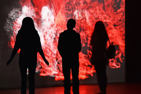 Moscow, Russia - January 28, 2016: people standing in front of an interactive installation in the exhibition center "Mars." Focus on the silhouetteのeditorial素材