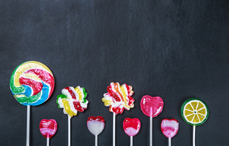 multicolored lollipops, candy and chewing gum on a black background.の写真素材