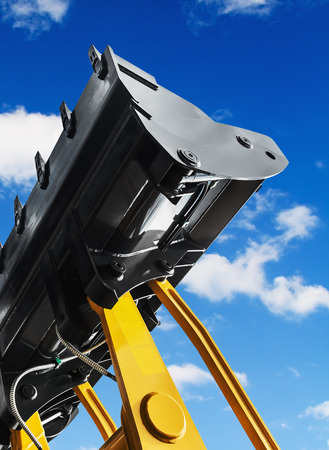 Construction excavator bucket against the sky with cloudsの写真素材