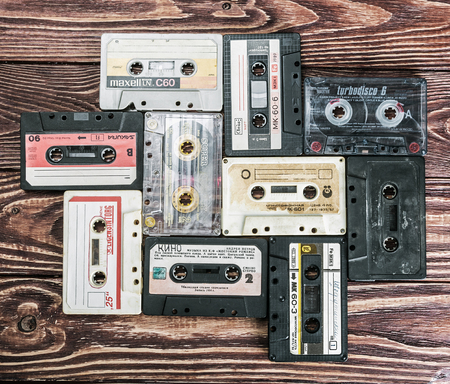 Moscow, RUSSIA - May 24, 2016: Old Cassette tapes over textured wooden table. Cassette tapes of different firms Maxell, Sakura, Svema etc.のeditorial素材