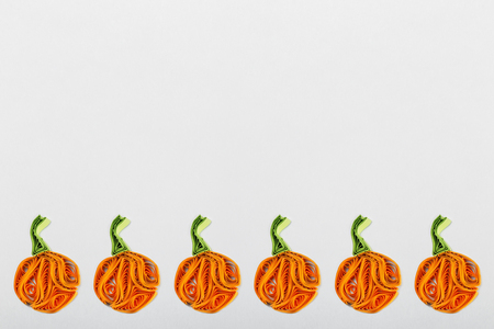 Pumpkins in quilling techniques for Halloween on a light backgroundの写真素材