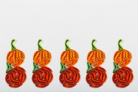 Pumpkins in quilling techniques for Halloween on a light backgroundの写真素材