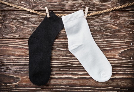 black and white textile socks hanging on the clothesline to dry. vignetting as an artistic effectの写真素材