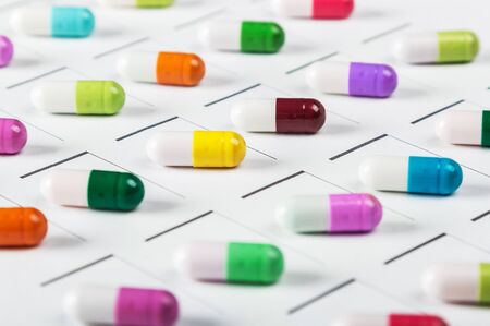 tablets of different colors on a plan of medicationの写真素材